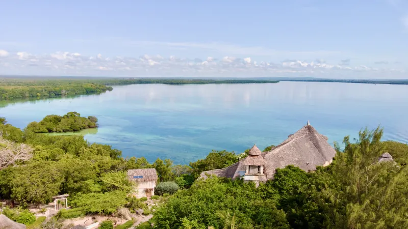 Aerial view of the thatched restaurant and lodges on their headland above Mida Creek